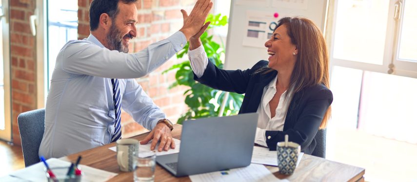 Two people high fiving during business conversation