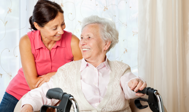 Middle aged woman and older woman sat closely together smiling