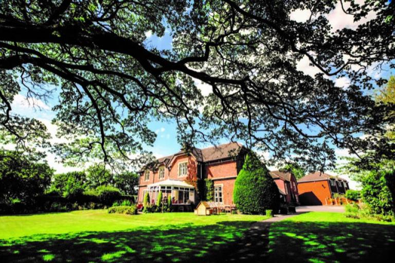 Old Rectory, a Care Home in Staffordshire, surrounded by trees and grass