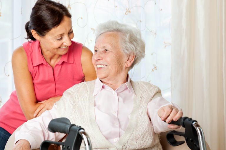 Middle aged woman and older woman sat closely together smiling